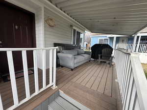 Wooden deck featuring a grill