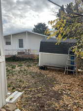 View of side of home with a shingled roof