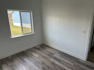 Empty room featuring wood finished floors and a textured wall