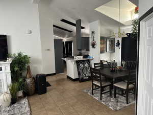 Tiled dining space with a textured ceiling and lofted ceiling