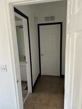 Corridor featuring tile patterned flooring and a textured wall