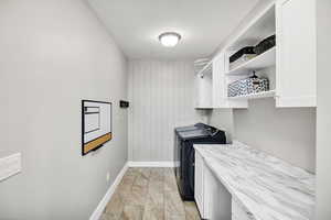 Laundry room featuring cabinet space, washer and clothes dryer.