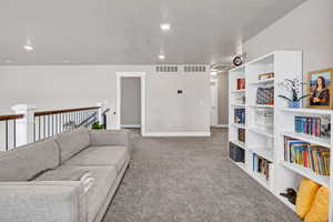 Carpeted loft  with baseboards and recessed lighting