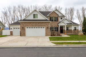 View of front of house featuring concrete driveway, brick siding, a garage, and a shingled roof
