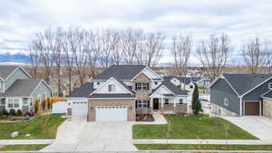 Craftsman-style house with concrete driveway, a residential view, brick siding, and a gate