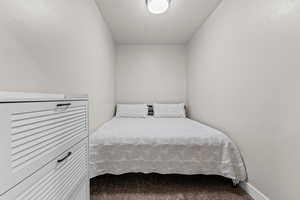 Carpeted bedroom with baseboards and a textured ceiling