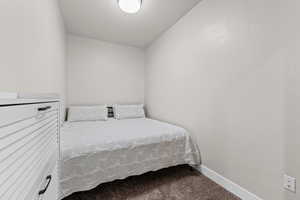 Carpeted bedroom with baseboards and a textured ceiling