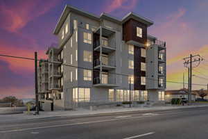 Property at dusk featuring a view of apartment building / complex