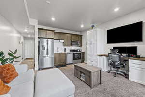Kitchen with stainless steel appliances, light countertops, a desk, recessed lighting, and backsplash