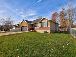 Ranch-style home featuring concrete driveway, brick siding, and a garage