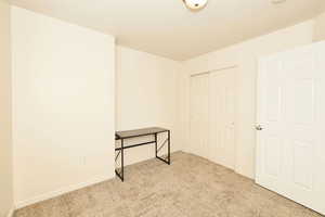 Unfurnished bedroom with light carpet and a closet