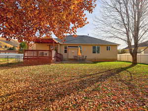 Rear view of house with a fenced backyard, a patio area, a wooden deck, and a shingled roof