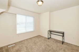 Empty room featuring carpet and baseboards