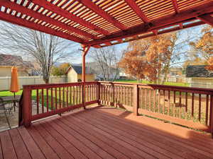 Wooden terrace with a fenced backyard and a shed