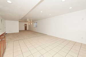 Unfurnished room with light tile patterned flooring, recessed lighting, light carpet, and a textured ceiling