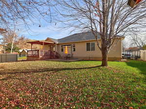 Rear view of property with a fenced backyard, a deck, and a patio area