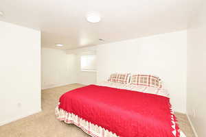 Bedroom featuring light colored carpet and a textured ceiling