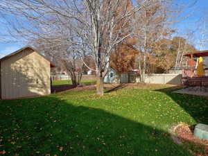 Fenced backyard featuring a storage shed