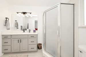 Full bathroom with vanity and a shower stall