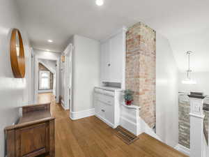 Hall with light wood-type flooring, lofted ceiling, an upstairs landing, and recessed lighting