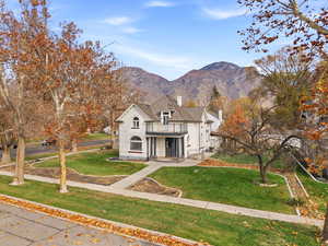 French country home featuring a front yard, a mountain view, stucco siding, and a porch