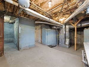 Unfinished below grade area featuring heating unit