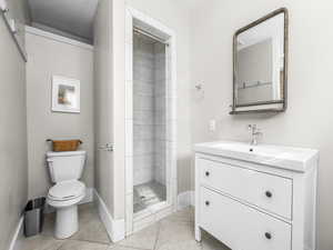 Bathroom featuring a stall shower, vanity, and light tile patterned flooring