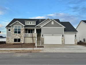 Craftsman house featuring stone siding, board and batten siding, roof with shingles, driveway, and covered porch