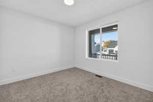 Empty room featuring baseboards and carpet flooring