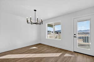 Unfurnished dining area with light wood finished floors, a chandelier, and a mountain view