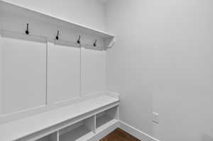 Mudroom featuring dark wood finished floors and baseboards