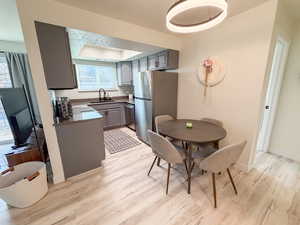 Dining room featuring light wood finished floors and a tray ceiling