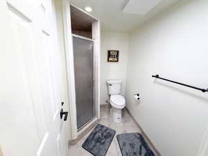 Bathroom with a shower stall and light tile patterned floors