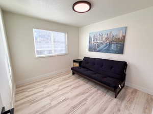 Sitting room featuring light wood-type flooring and a textured ceiling