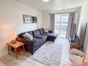 Living room featuring light wood-style flooring and a textured ceiling