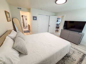 Bedroom featuring light wood finished floors and a closet