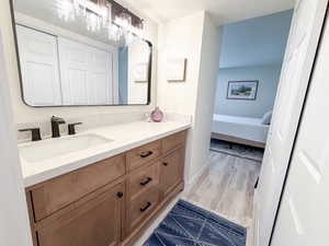 Bathroom with vanity, light wood-style floors, and a textured ceiling