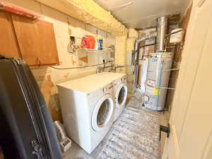 Laundry room with washing machine and dryer, secured water heater, and unfinished concrete flooring
