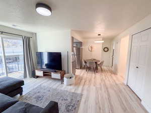Living room featuring a textured ceiling and light wood-style floors