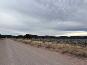 View of dirt / gravel road with a mountain view and a view of rural / pastoral area