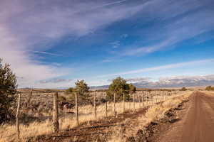 View of dirt / gravel road featuring a mountain view and a view of rural / pastoral area