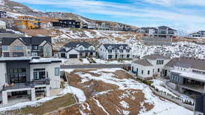 Snowy aerial view featuring a residential view and a mountain view