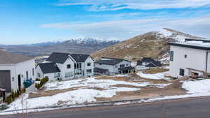 Snowy aerial view with a mountain view and a residential view