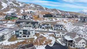 Snowy aerial view featuring a residential view and a mountain view