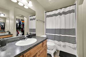 Bathroom with vanity, a walk in closet, shower / bath combo, and light tile patterned flooring