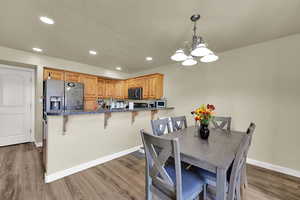 Dining room with recessed lighting, light wood-style floors, and a chandelier