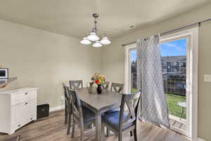 Dining area featuring light wood-type flooring and a chandelier