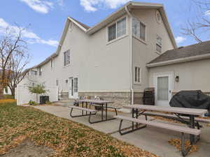 Back of house with entry steps, a patio, and stucco siding