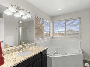 Full bath featuring a stall shower, a garden tub, and vanity