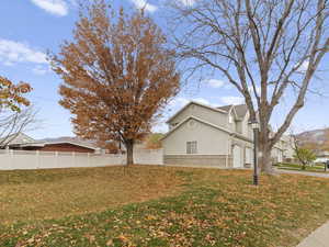 View of side of property with stucco siding, an attached garage, and brick siding